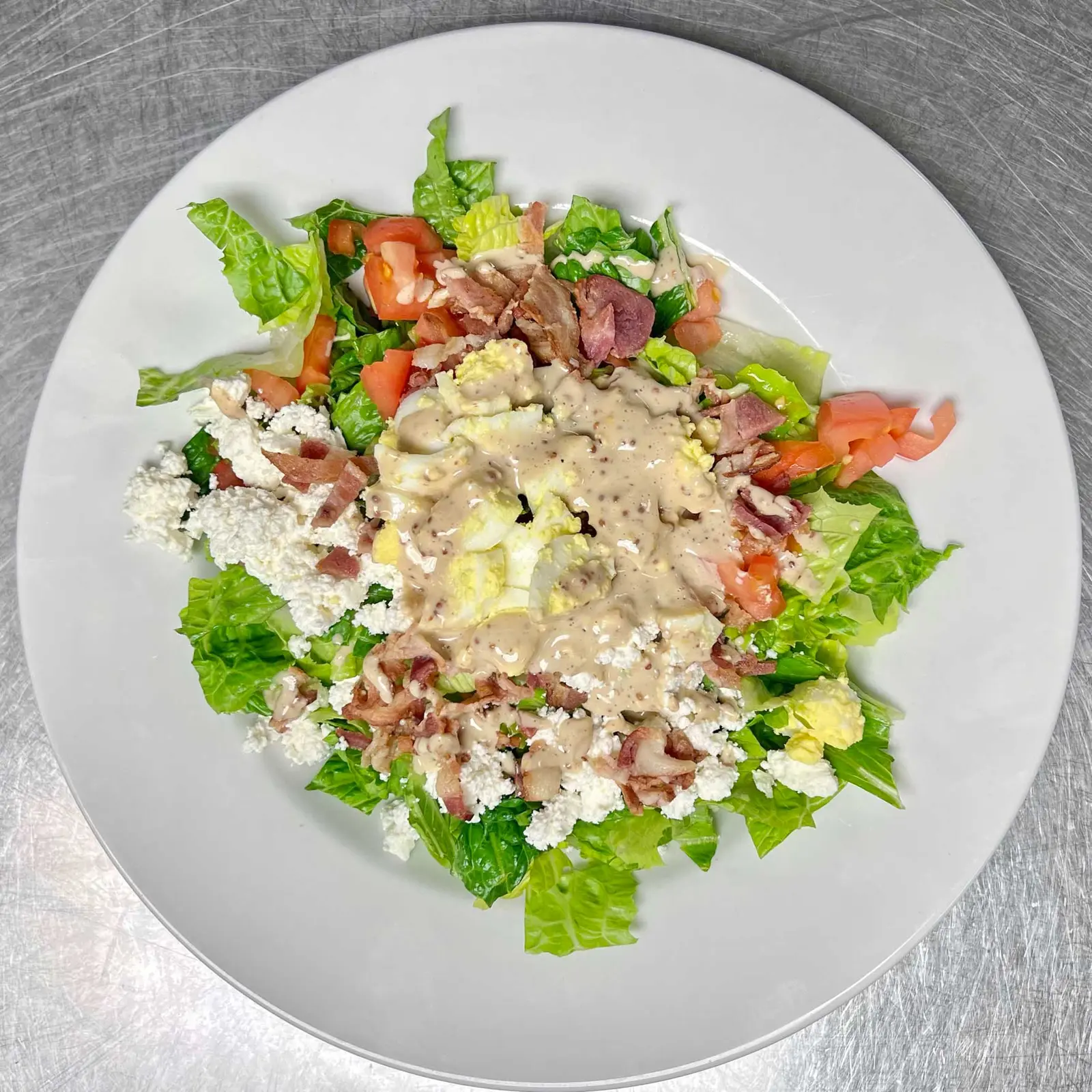 A cobb salad on a white plate