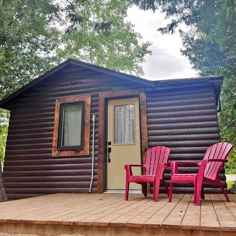 Two red chairs on the deck of the Ash, a 1 bedroom cabin