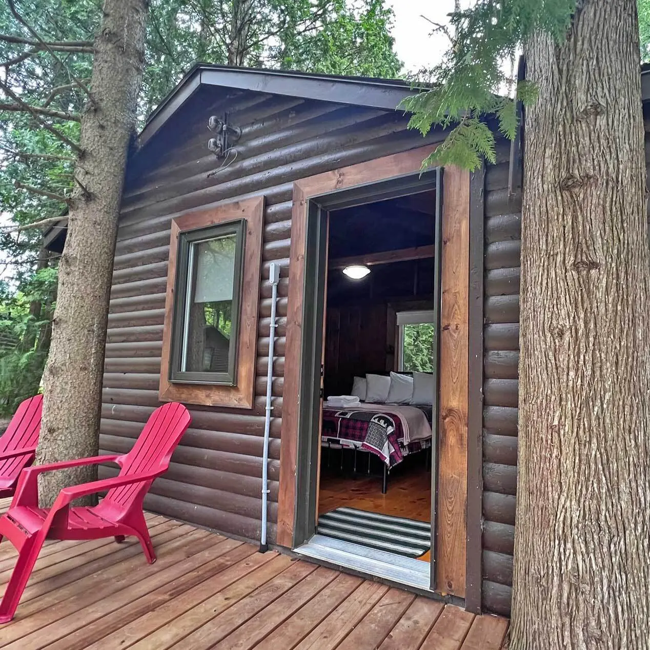 The door of the Tamarack open onto the deck, red chairs outside