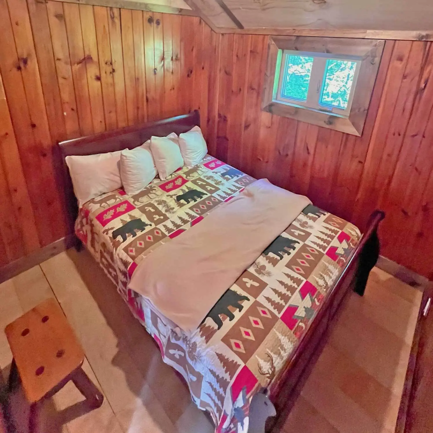 A queen bed with a bear-print quilt inside the White Cedar
