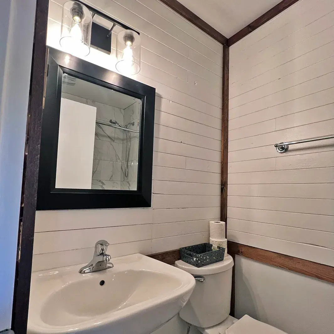 White shiplap walls, sink and mirror in a lodge room bathroom