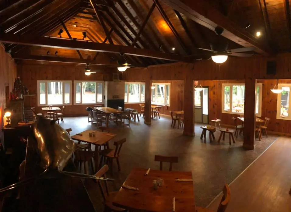 The great hall under the lodge rooms, with its timber rafters and long wood tables
