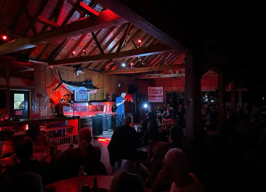 A band playing at the far end of the lodge, the room lit red and guests at the tables